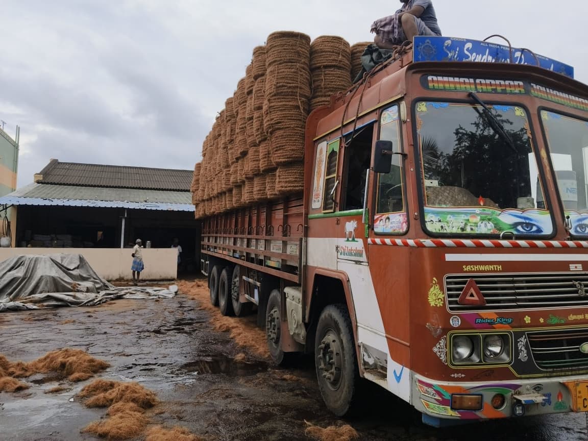 Workers loading rolled coir bundles onto a lorry at the Dharmapuri facility